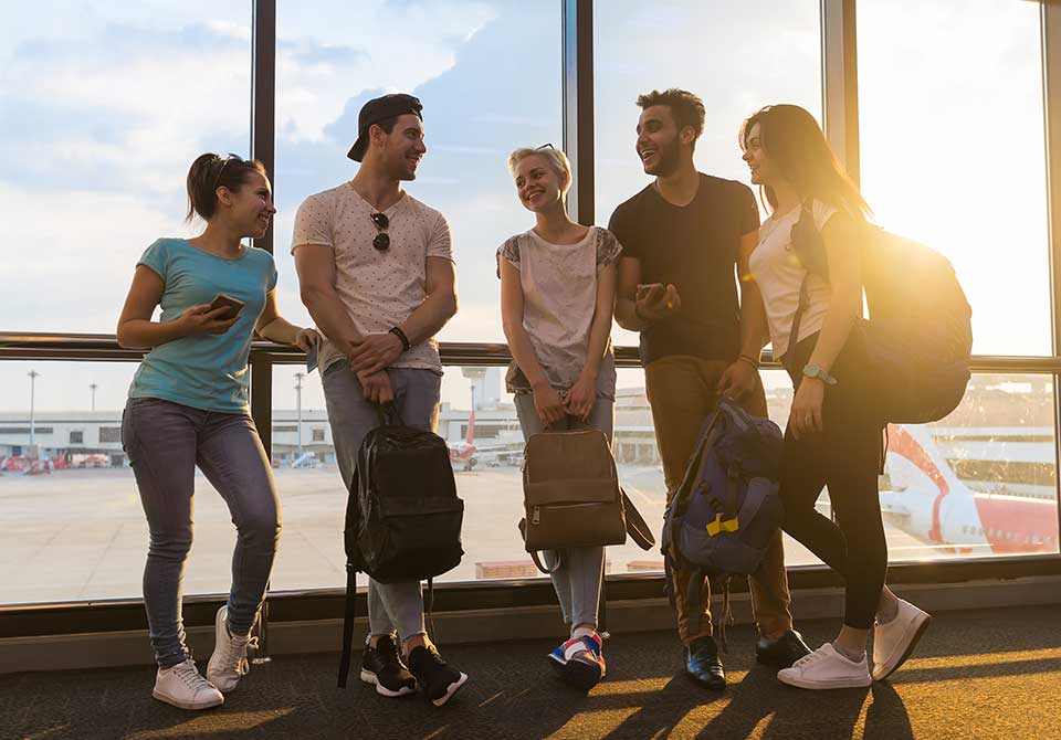 Young group of smiling travelers in airport